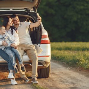 Family in a forest. People by the car. Sunset background.